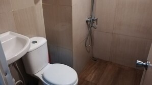 A small bathroom with a toilet, sink, and shower. - Hotel O Apartment Grand Asia Afrika By Prisma (Bandung)