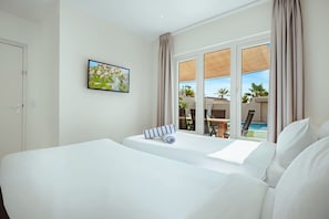 Una habitación de hotel con una cama grande, una ventana con vistas a la piscina y un cuadro en la pared.
