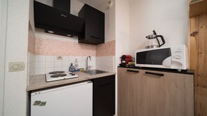 A compact kitchen with a white refrigerator, a microwave, a sink, and a stove. - Pleasant studio 4 ppl near the slopes (Allos)