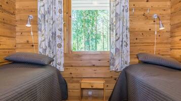 Une chambre de cabine avec deux lits, une petite table de chevet en bois et une fenêtre avec des rideaux.