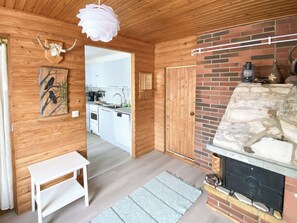 Un intérieur en bois comprenant une cuisine, une cheminée et une table blanche.