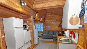 Une petite cabine comprenant un coin cuisine, un espace repas et un salon avec un canapé et une fenêtre.