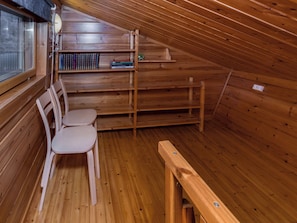 A wooden interior with a sloped ceiling, a wooden bench, and a chair. - Pohjaslahdentie 17 b by Interhome (Kuusamo)