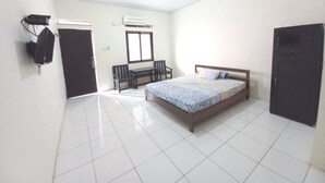 A bedroom with a bed, a desk, and a chair. There is a window and an air conditioning unit on the wall. - OYO LIFE 93634 Penginapan D'palinggihan Syariah (Sumber)