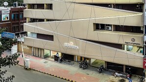A multi-story hotel with a modern architectural design, featuring a prominent sign for 'Hotel Nava Ratna'. - Navaratna Delight (Coimbatore)