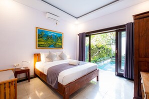 A bedroom with a bed, bedside table, and a painting on the wall.