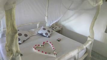 A bed with a canopy, a bedside table, and a heart-shaped decoration on the bed.
