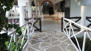 A covered walkway with white railings, leading to a staircase and a room with a view. - Safina Beach House (Watamu)