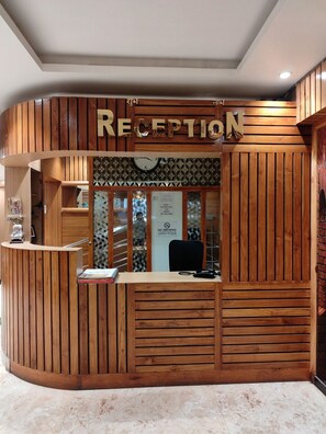 Una recepción con diseño de madera, un reloj y un cartel de prohibido fumar.