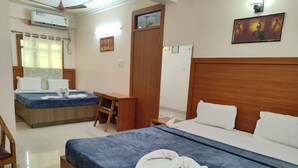 Ein Hotelzimmer mit Bett, Schreibtisch, Stuhl, Kleiderschrank und Klimaanlage.