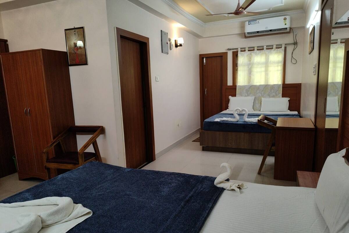A hotel room with a bed, a desk, a wardrobe, and a chair.
