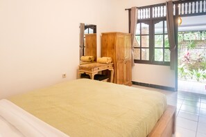 A bedroom with a bed, wooden wardrobe, and a window with curtains. - Sandora Homestay by Supala (Ubud)