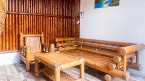 A room with a bamboo sofa set, a small table, and a chair. - Sandora Homestay by Supala (Ubud)