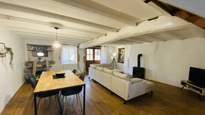 Ein gemütliches Wohnzimmer mit einem Holzesstisch, einem weißen Sofa und einem Kamin.