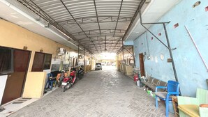 A covered corridor with a tiled floor, metal ceiling, and walls painted in light blue. - Hotel O Hidayah Homestay Syariah (Sidoarjo)