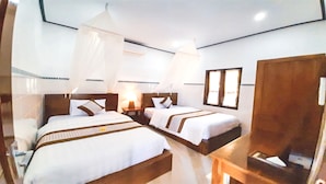 Ein Hotelzimmer mit zwei Betten, einem Holz-Kopfteil, einem Nachttisch, einem Schrank und einem Fenster.