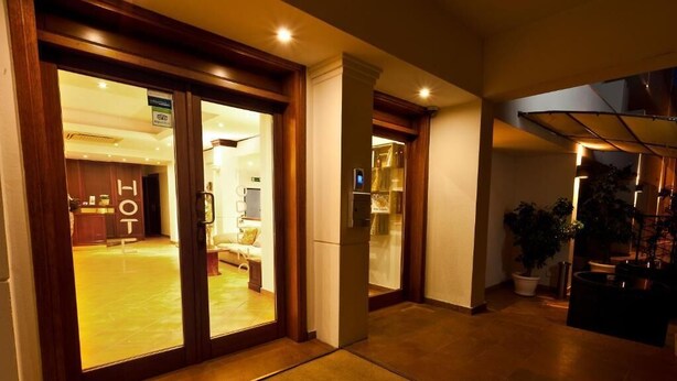 L’entrée d’un hôtel au design moderne, un comptoir d’accueil et une vue sur l’intérieur d’une chambre.