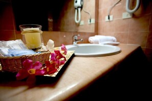 Une salle de bain équipée d’un lavabo, d’un miroir et d’un panier contenant des articles de toilette.