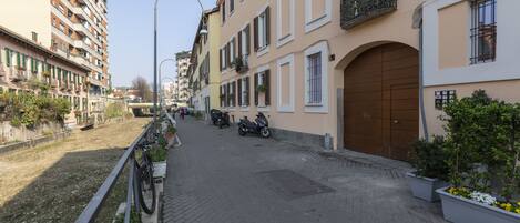 A street with buildings, a bicycle, and a motorbike.