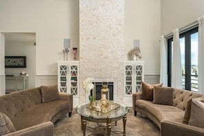 Relax in a comfortable living space with a curved sofa, fireplace, and decorative accents.