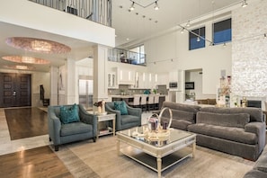 Relax in this stylish living area with a mezzanine level, sofa, armchair, and glass coffee table.