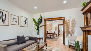 Ein Wohnzimmer mit einer Couch, einem Couchtisch und einem Essbereich mit Stühlen und einem Tisch.
