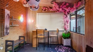 A cozy room with a wooden desk, two chairs, a window with blinds, and a decorative pink floral arrangement. - Insta-Worthy 5BR Home I Pet Friendly  I Firepit (Denver)