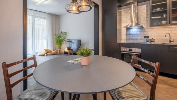 A modern kitchen with dark cabinetry, a built-in oven, and a stainless steel sink. - NEW SOHO 13 - TOP Center, black & white (Sofia)