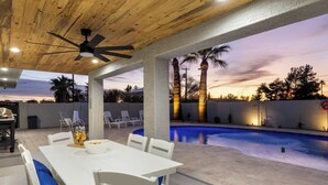 An outdoor patio with a pool, white furniture, and palm trees. - Private Pickleball, B-Ball, Putt, Pool, Spa, Grill (Scottsdale)