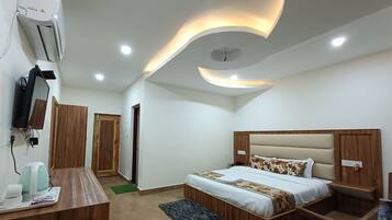 A modern bedroom with a bed, bedside tables, a desk, and a TV.