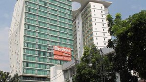 A multi-story building with a prominent sign for 'Merdeka Factory Outlet'. - Capital O 93636 La Grande Apartment By UJM (Bandung)