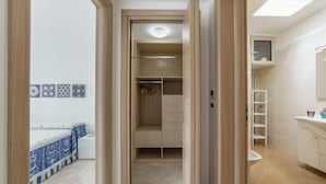 Ein Schlafzimmer mit Bett, Schrank und Bad mit Waschbecken und Toilette.