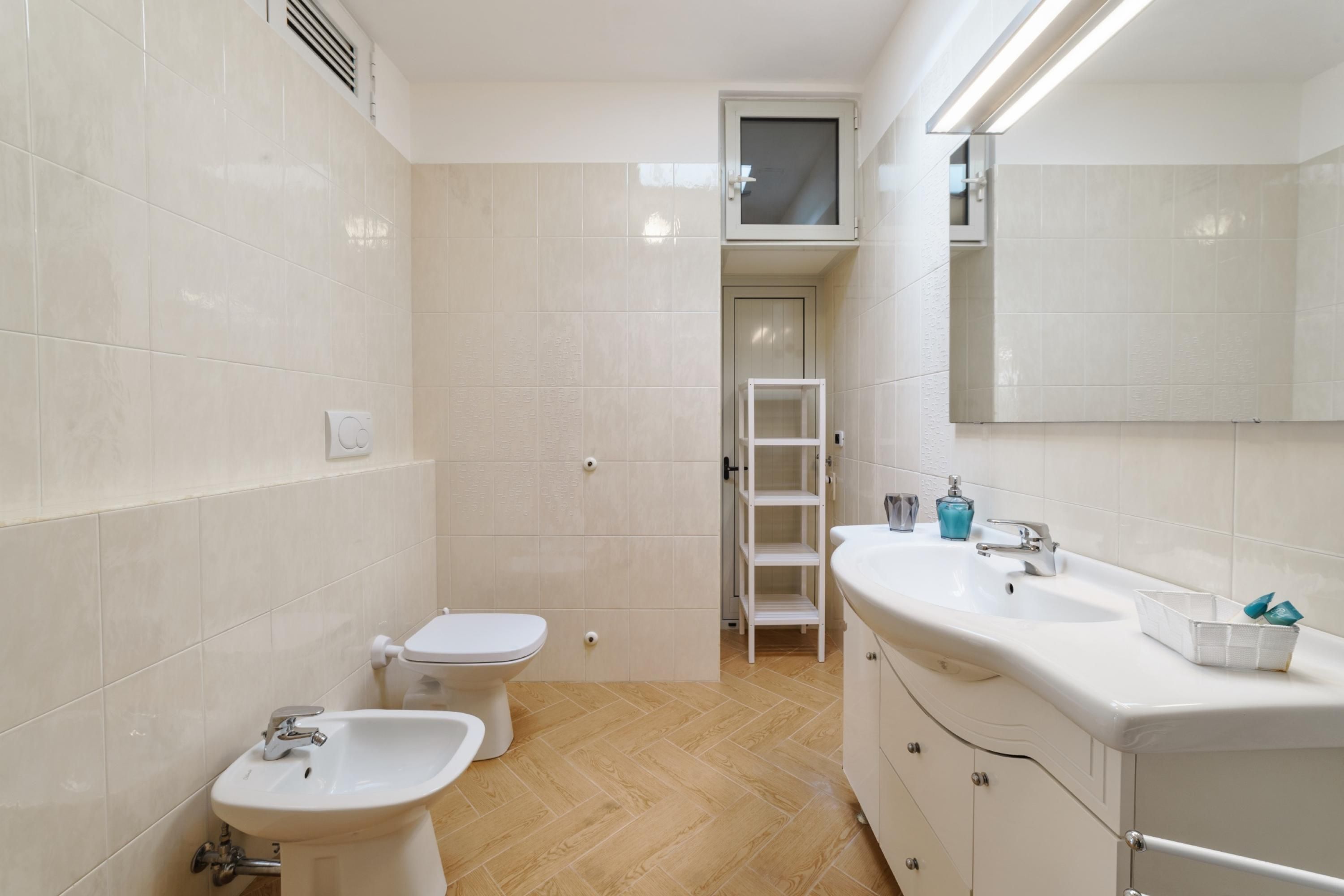 Un bagno moderno con WC, bidet e lavabo.