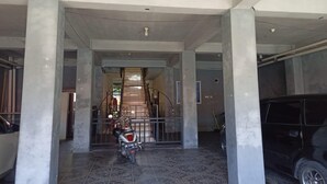 A spacious lobby with a marble floor, a black SUV, and a scooter parked near a gated entrance. - Hotel O Pondok Baruga 777 Near Sarewo Musik Studio Kendari (Kendari)