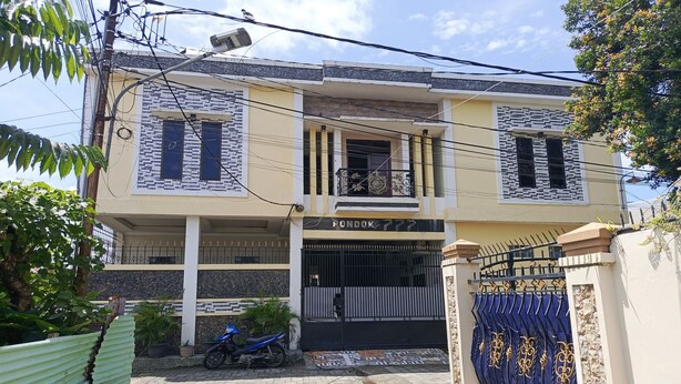 A two-story building with a balcony, a gated entrance, and a motorcycle parked outside. - Hotel O Pondok Baruga 777 Near Sarewo Musik Studio Kendari (Kendari)
