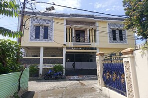 A two-story building with a balcony, a gated entrance, and a motorcycle parked outside. - Hotel O Pondok Baruga 777 Near Sarewo Musik Studio Kendari (Kendari)