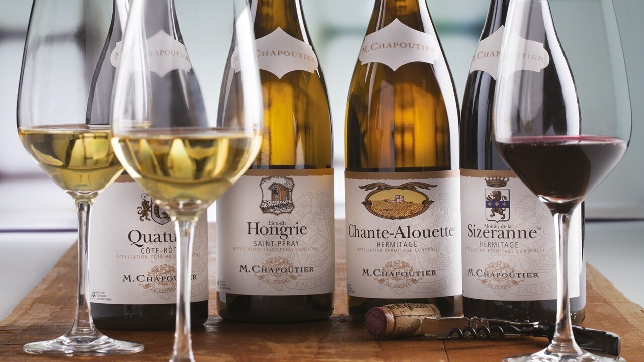 Bottles of wine and glasses on a wooden surface.