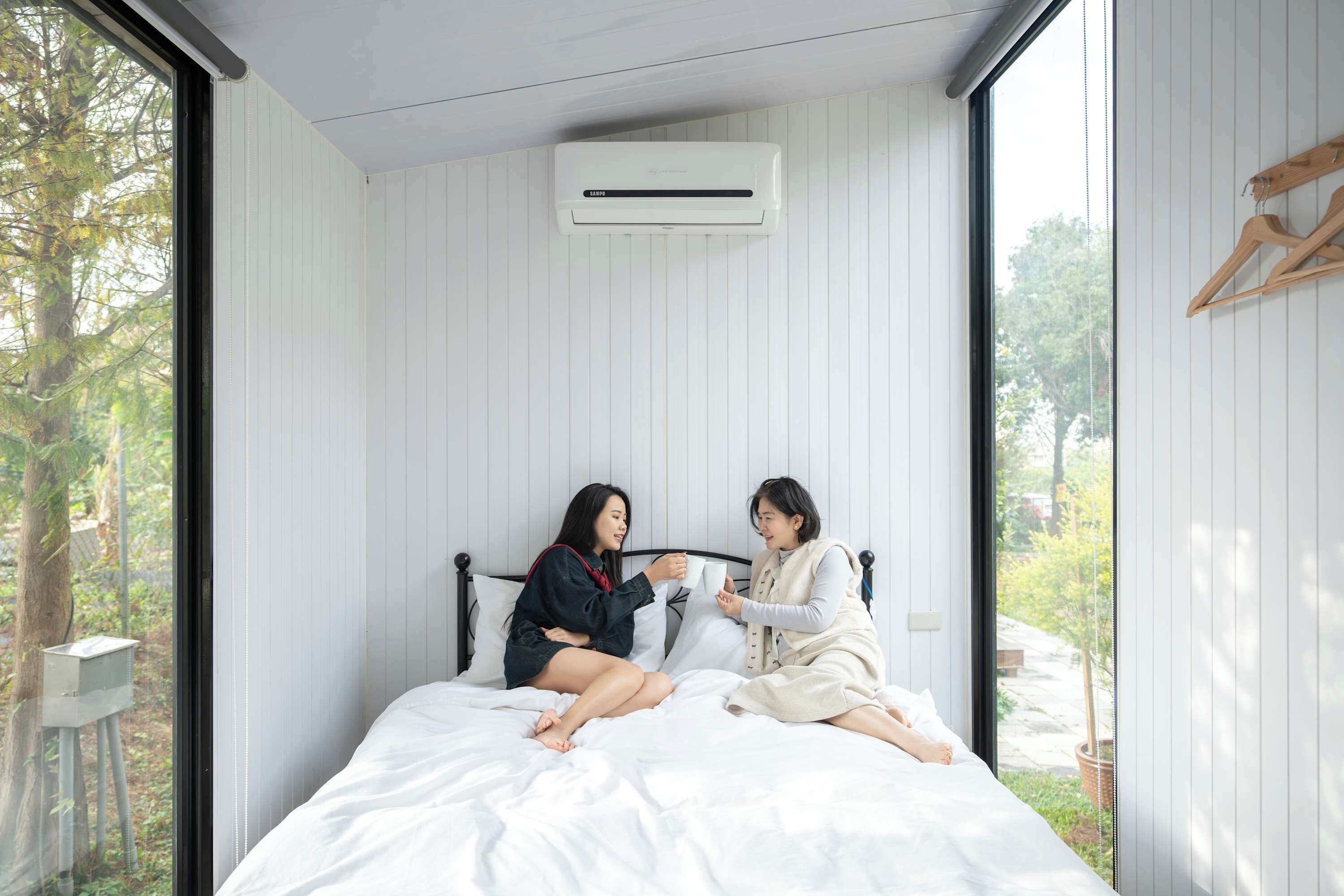 A bedroom with a bed, a window, and an air conditioning unit.