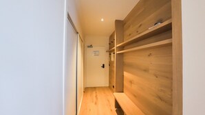A narrow hallway with wooden flooring and built-in shelving units.