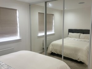 A bedroom with a bed, a window, and a radiator. - Immaculate 4-bed House in Horley (Horley)