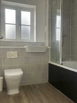 A bathroom with a toilet, sink, and shower. - Immaculate 4-bed House in Horley (Horley)