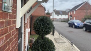 A residential street with a brick house, a mailbox, and a neatly trimmed hedge. - Immaculate 4-bed House in Horley (Horley)