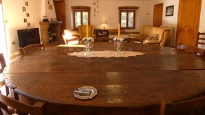 A dining area with a large wooden table, chairs, a fireplace, and a cozy seating arrangement. - SCAPPO IN UMBRIA, The Piccino (Amelia)