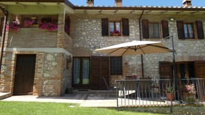 A stone building with a balcony, a covered patio with a table and chairs, and flower boxes on the windowsills. - SCAPPO IN UMBRIA, The Piccino (Amelia)