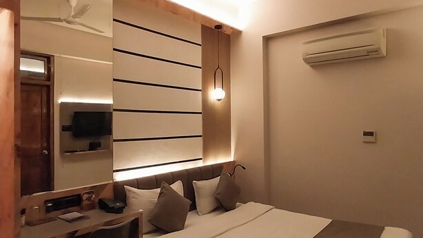 Quarto moderno com cama, escrivaninha e ventoinha de teto.