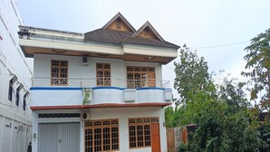 A two-story residential building with a balcony, large windows, and a garage. - Hotel O Karunia Kost & PenginapanNearSiring Marabahan (Ulek Barito) (Marabahan)