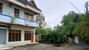 A two-story building with a balcony, large windows, and a courtyard. - Hotel O Karunia Kost & PenginapanNearSiring Marabahan (Ulek Barito) (Marabahan)
