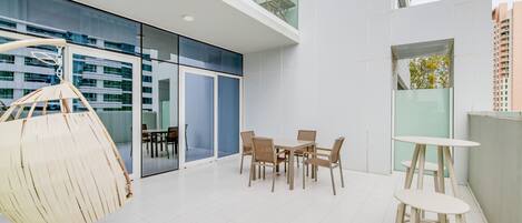 A modern interior with a dining area, a hanging chair, and a small table.