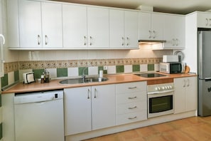 A kitchen with white cabinets, a microwave, a dishwasher, and a stove.