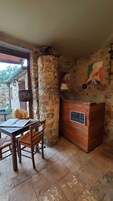Una habitación rústica con una pared de piedra, un mostrador de recepción de madera y una mesa con sillas.